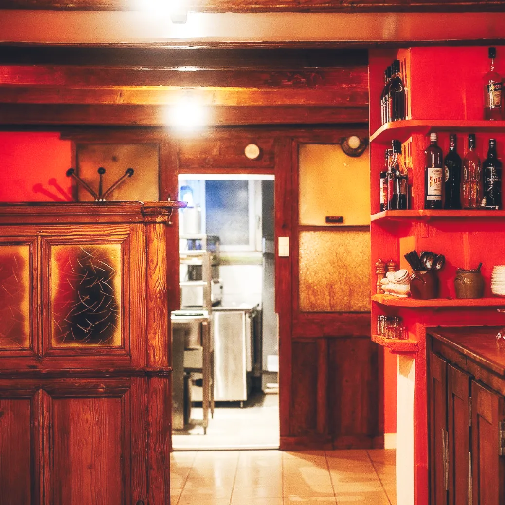 Intérieur authentique du bouchon lyonnais Chez Mounier — boiseries, murs rouges et ambiance chaleureuse typique de la Rue des Marronniers